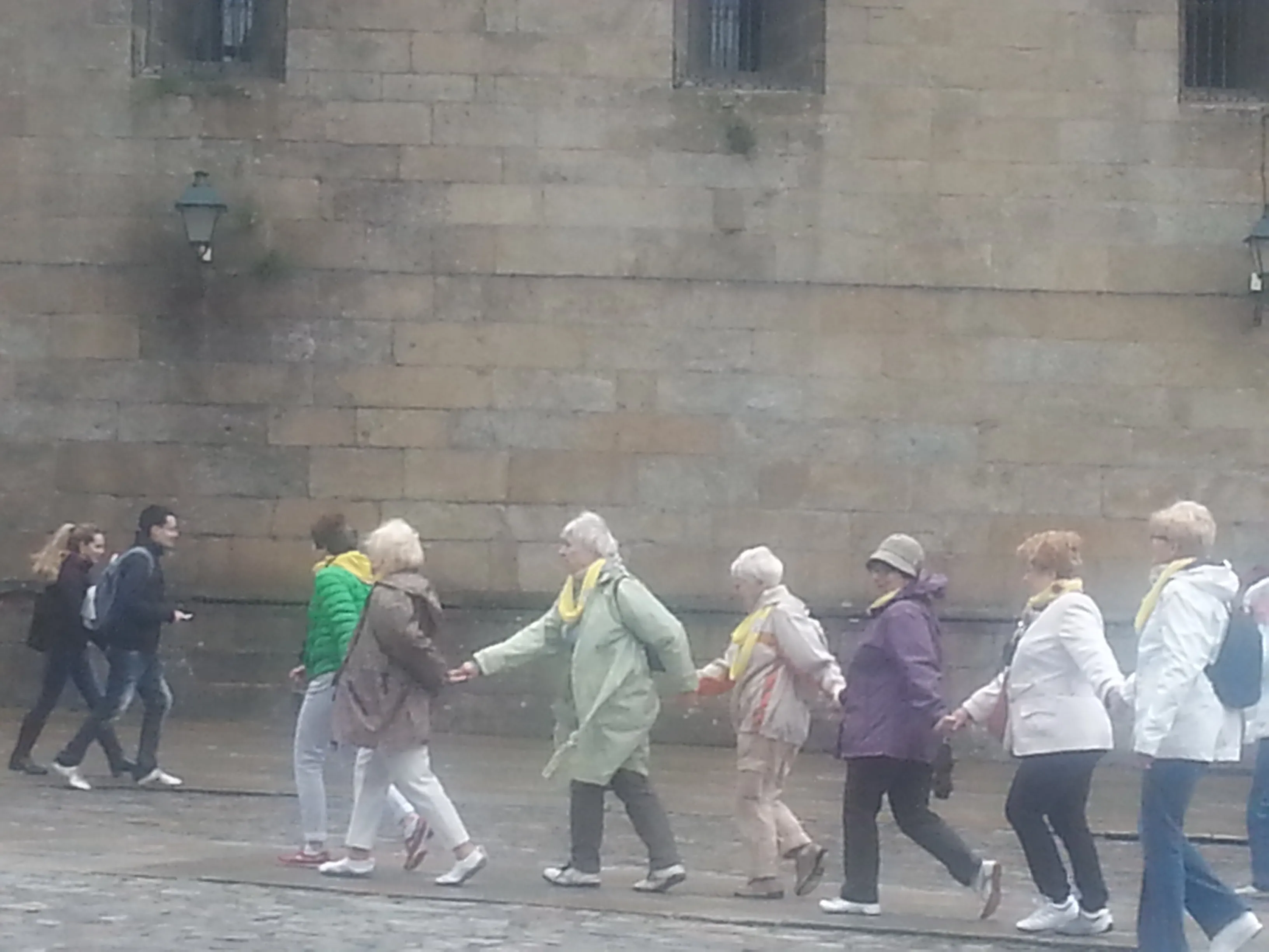 Pilgrims beginning a Camino stage in gentle morning light.