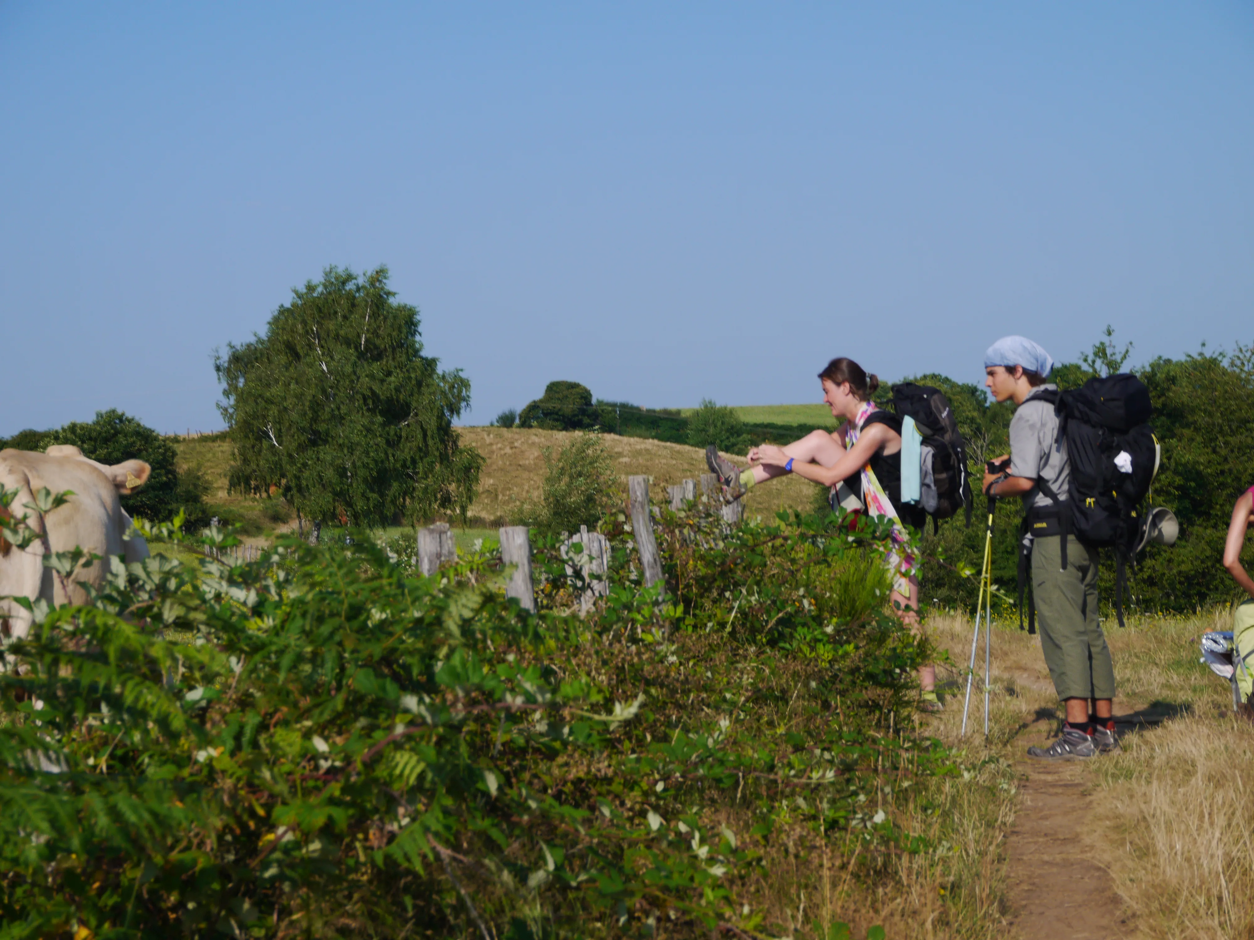 Pilgrims pausing to loosen a leg before continuing their Camino stage.