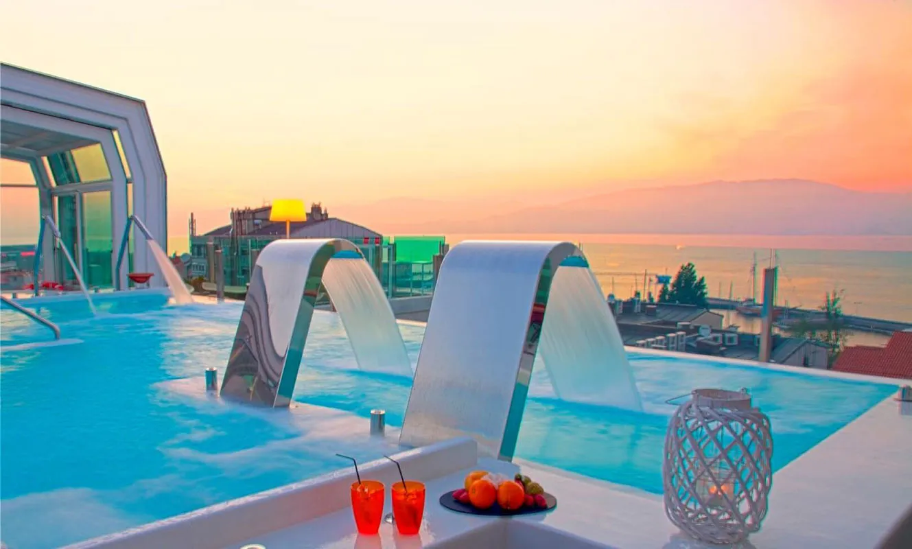 A peaceful hotel pool overlooking the water at sunset.