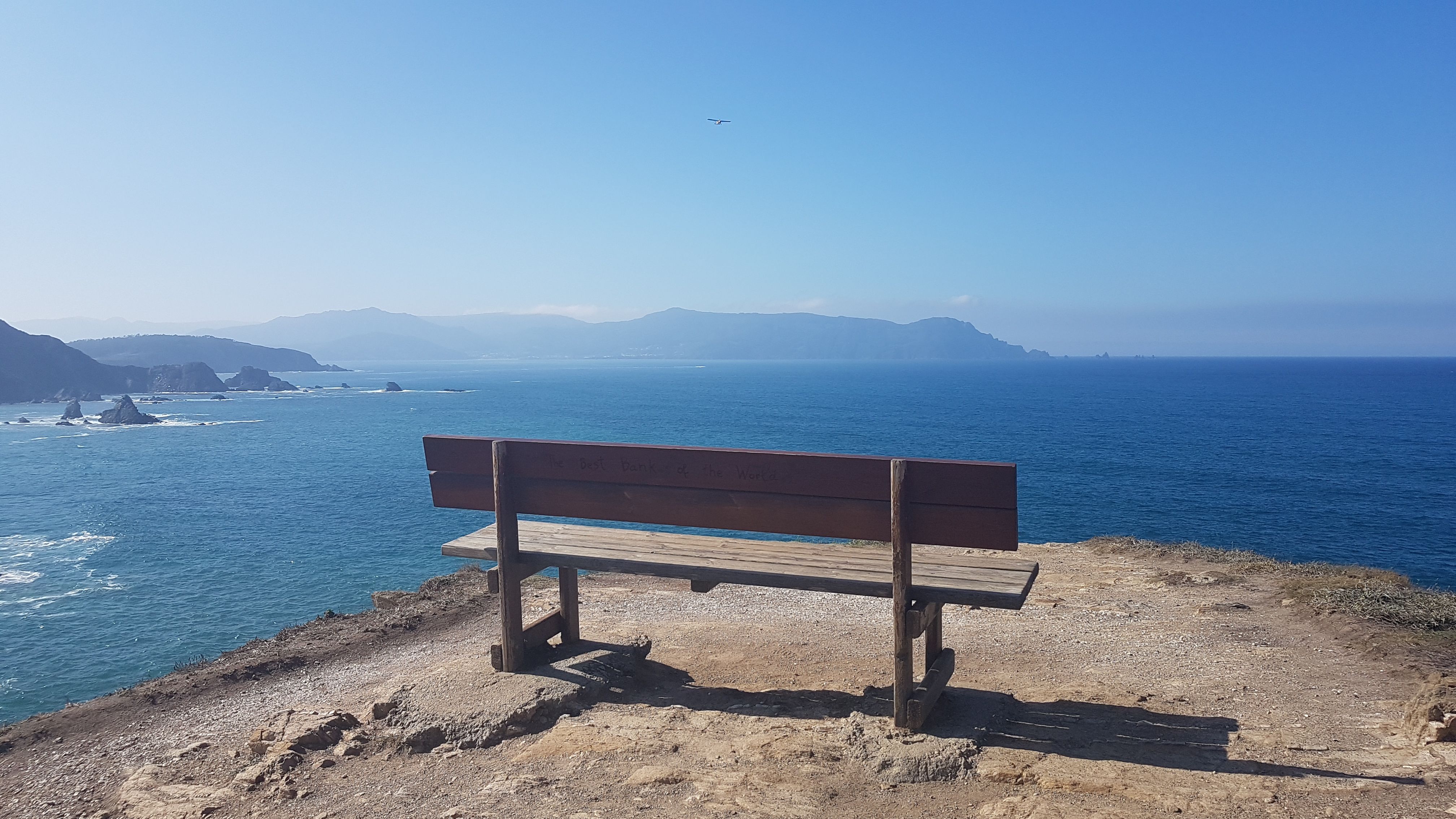 A bench overlooking the Atlantic coast and cliffs of Galicia.