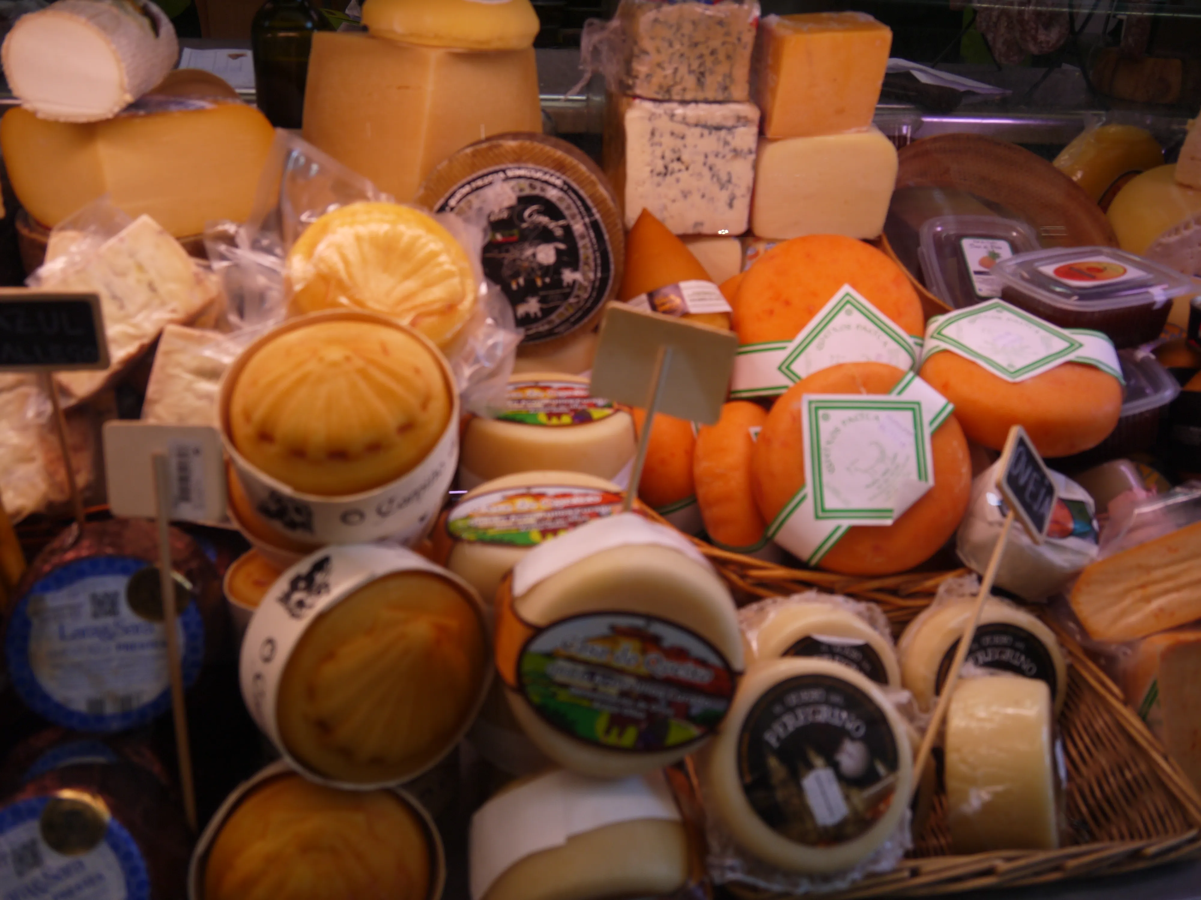 Galician cheeses displayed at a food market.