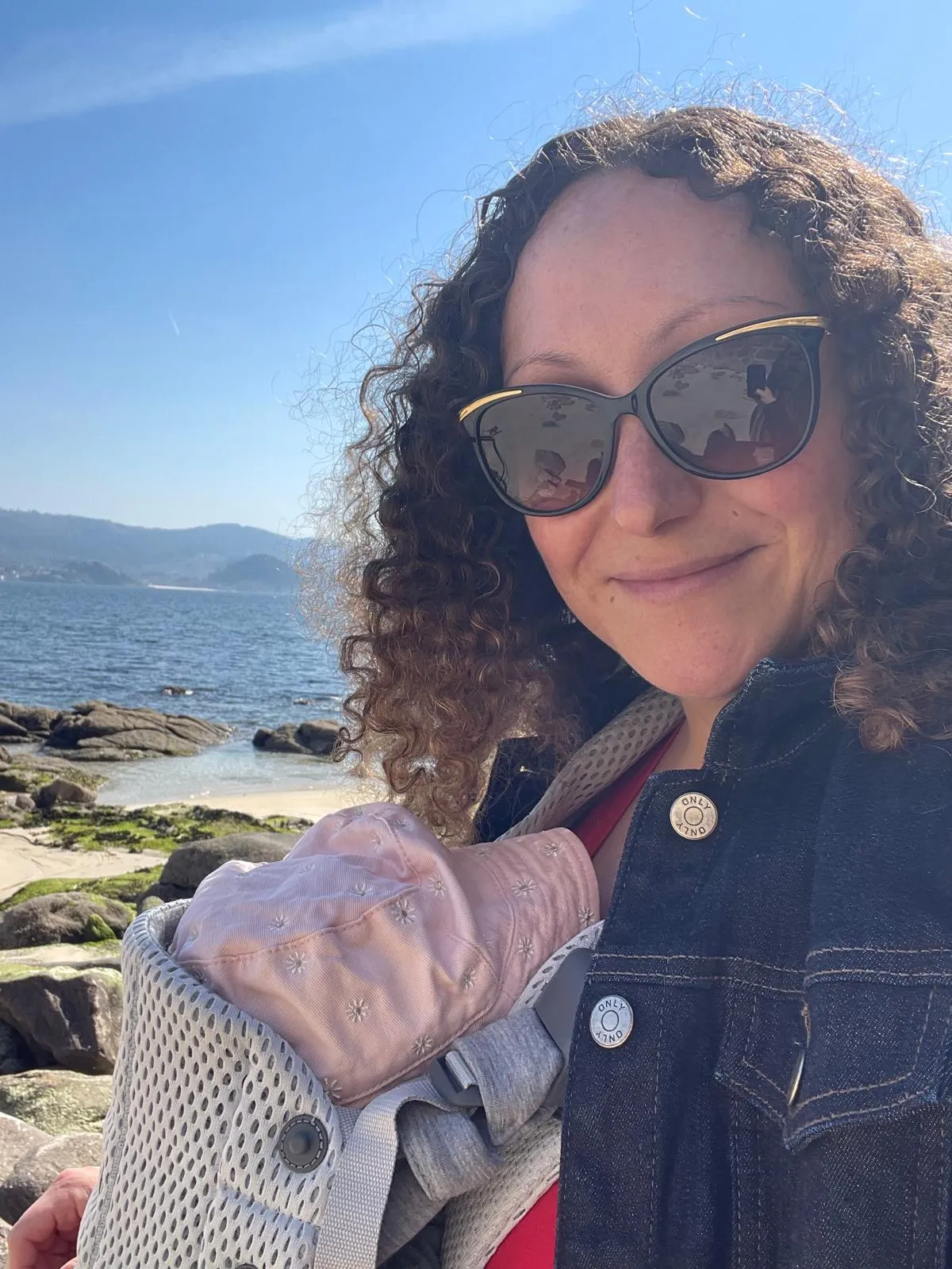 Ultreya Tours founder Nellie Meunier carrying her baby beside the Galician coast.