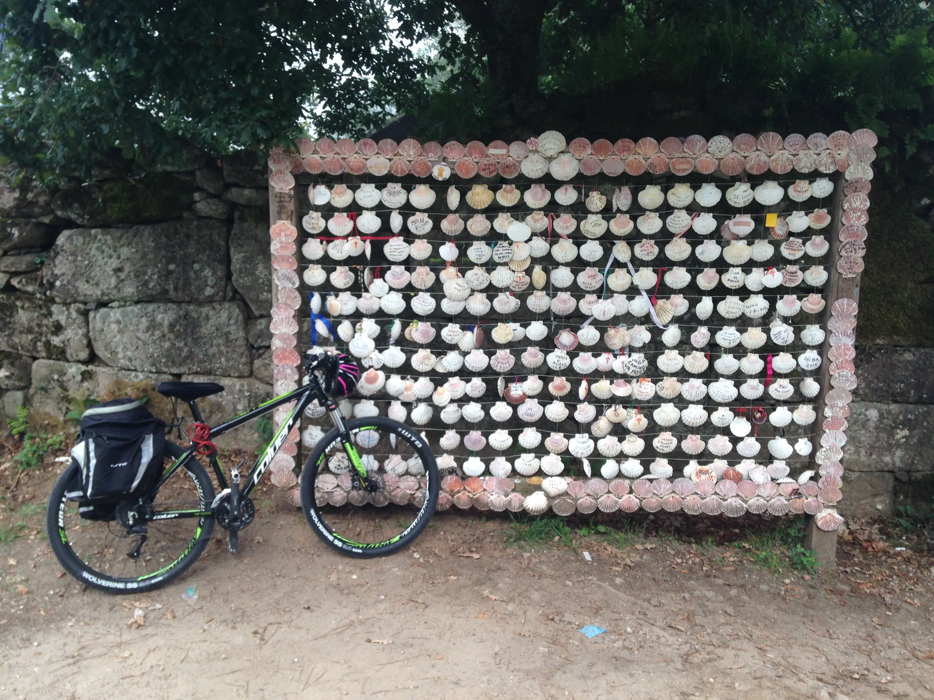 A touring bicycle beside a Camino shell marker on the Portuguese Way.