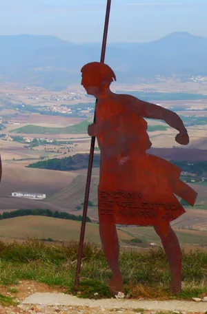 A pilgrim monument overlooking a mountainous Camino landscape.