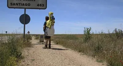 Des pèlerins avancent sur un chemin de Saint-Jacques balisé.